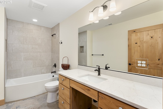 full bathroom featuring tiled shower / bath, vanity, and toilet