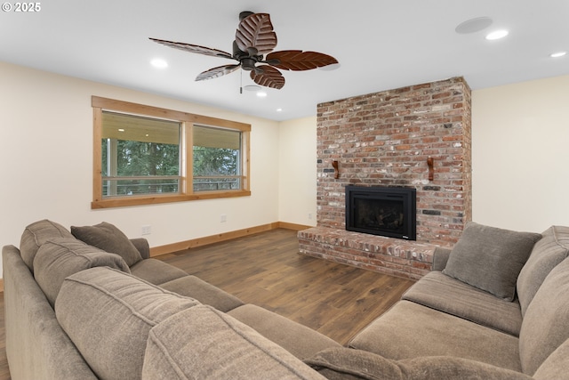 living room featuring dark hardwood / wood-style floors, ceiling fan, and a brick fireplace