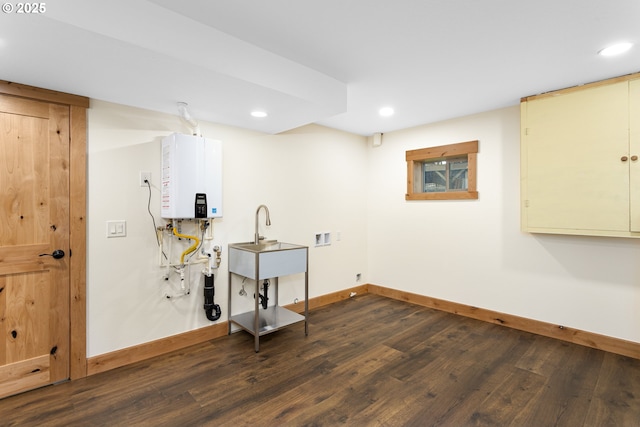 laundry room with tankless water heater, dark hardwood / wood-style flooring, sink, and hookup for a washing machine