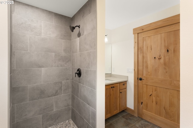 bathroom featuring tile patterned floors, vanity, and tiled shower