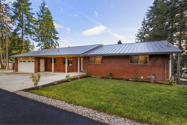 single story home featuring covered porch, a front yard, and a garage