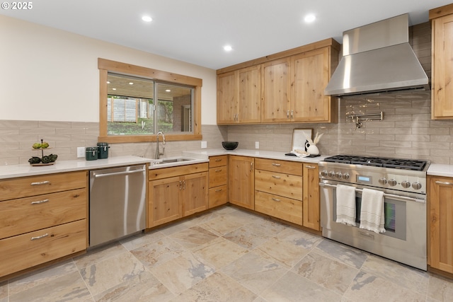 kitchen with appliances with stainless steel finishes, backsplash, wall chimney exhaust hood, and sink