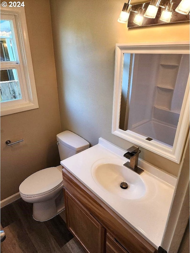 bathroom with toilet, vanity, and hardwood / wood-style floors