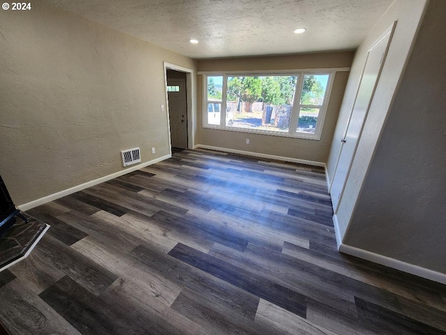 interior space with dark hardwood / wood-style flooring and a textured ceiling