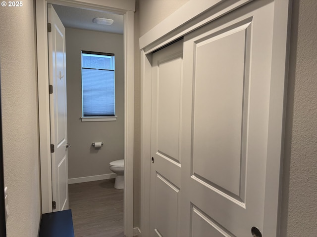 bathroom featuring baseboards, toilet, and wood finished floors