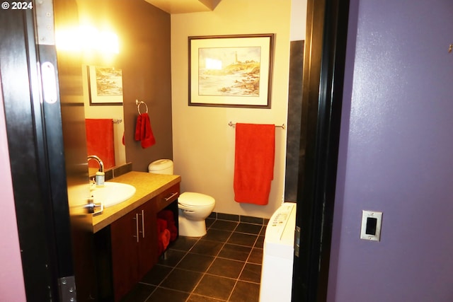 bathroom featuring tile flooring, vanity, and toilet