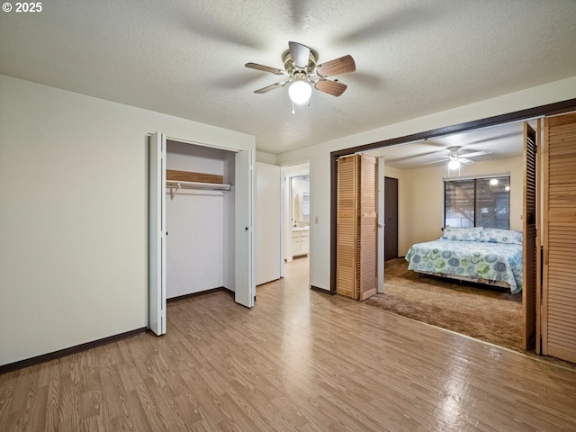 unfurnished bedroom with ceiling fan, a textured ceiling, and light wood-type flooring