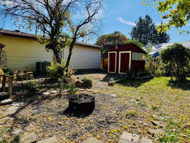 view of yard featuring an outdoor fire pit and a storage shed