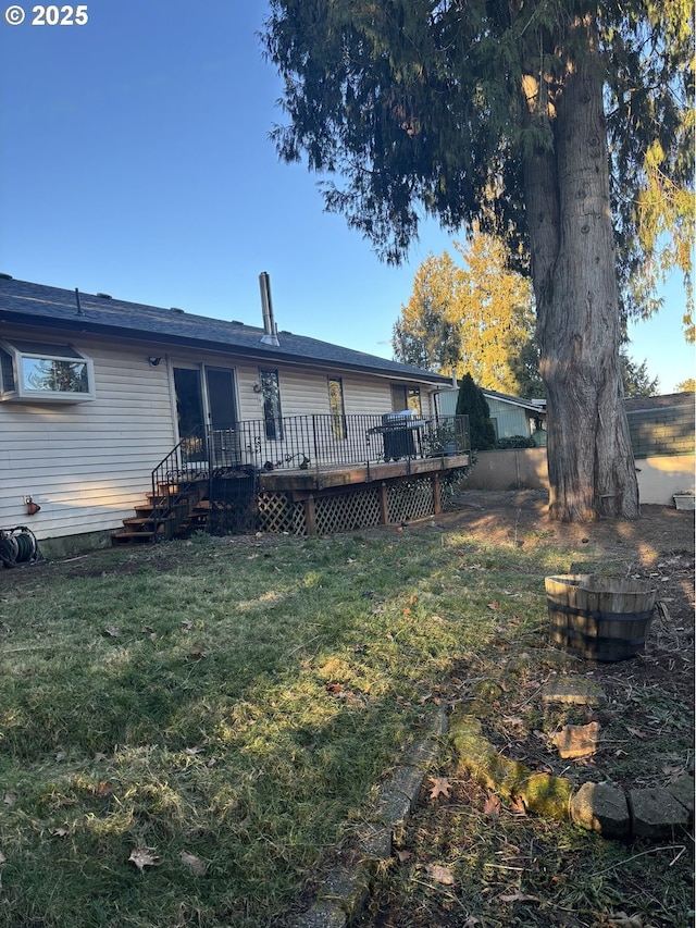 rear view of property with a deck and a lawn