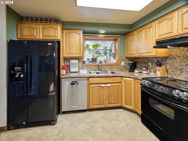 kitchen with light stone counters, sink, decorative backsplash, and black appliances