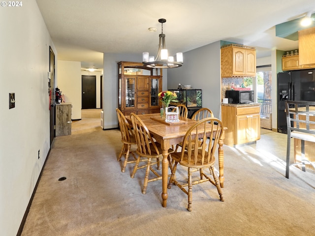 dining room featuring an inviting chandelier and light colored carpet