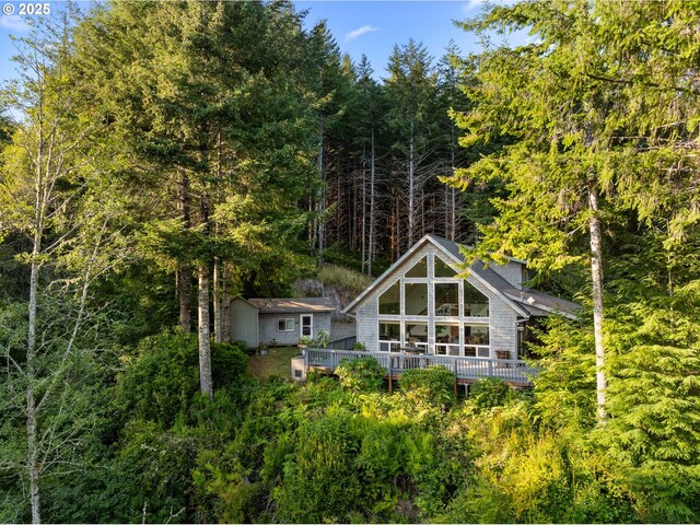 rear view of property with a shed and a deck