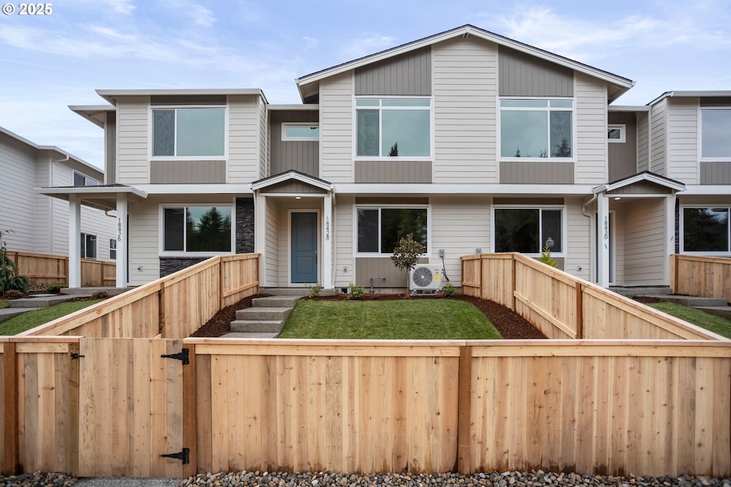 view of front of property with a front lawn and ac unit