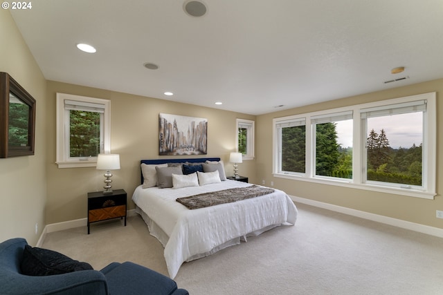 bedroom with visible vents, recessed lighting, light colored carpet, and baseboards