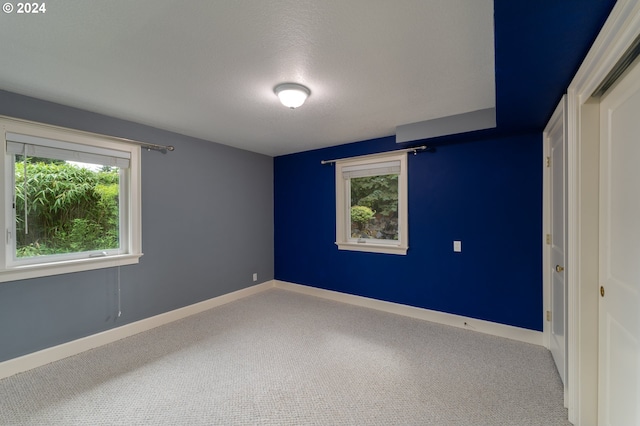 unfurnished bedroom featuring baseboards, carpet floors, and a textured ceiling