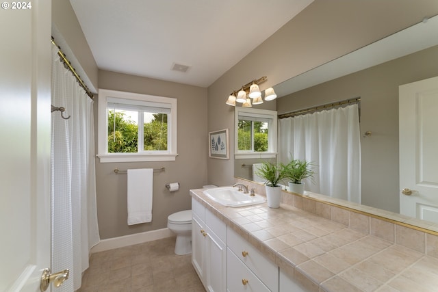 bathroom featuring visible vents, baseboards, toilet, and vanity