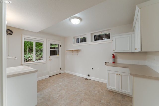 laundry area with electric dryer hookup, a sink, cabinet space, baseboards, and hookup for a washing machine