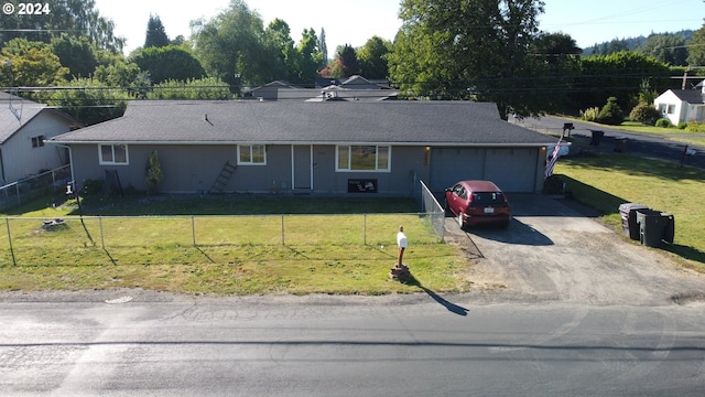 ranch-style house featuring a front yard and a garage