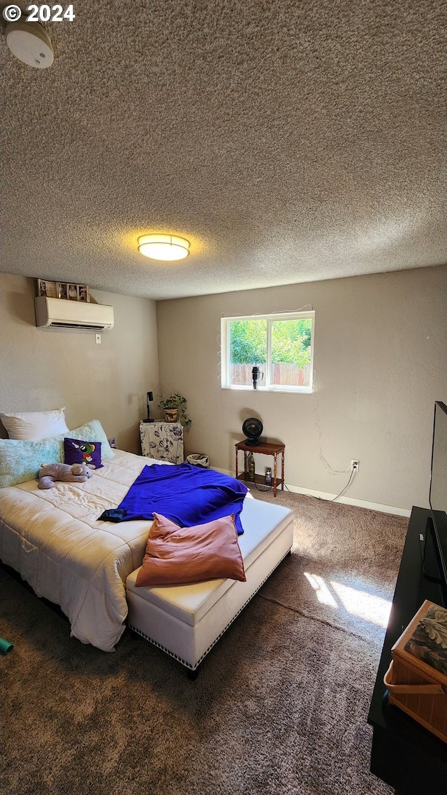 bedroom featuring carpet flooring, a textured ceiling, and a wall mounted AC