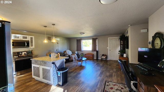 kitchen featuring decorative backsplash, appliances with stainless steel finishes, dark hardwood / wood-style flooring, pendant lighting, and white cabinetry