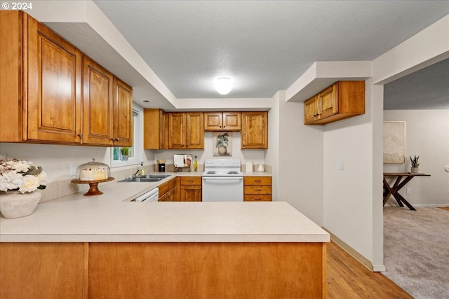 kitchen with a textured ceiling, kitchen peninsula, sink, and electric range