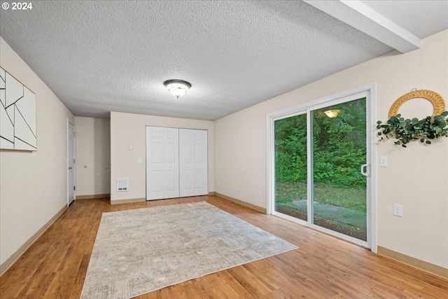 unfurnished bedroom featuring access to exterior, light hardwood / wood-style flooring, a closet, and multiple windows