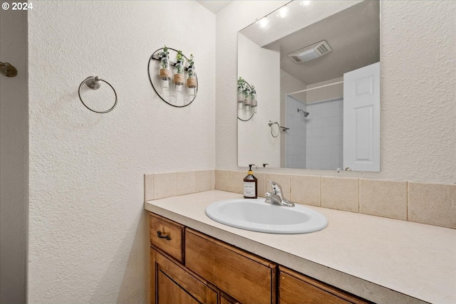 bathroom featuring vanity and a shower