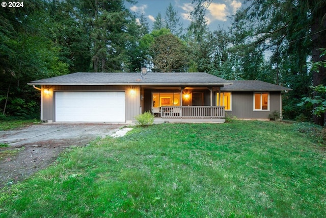 view of front of home featuring a yard, a porch, and a garage