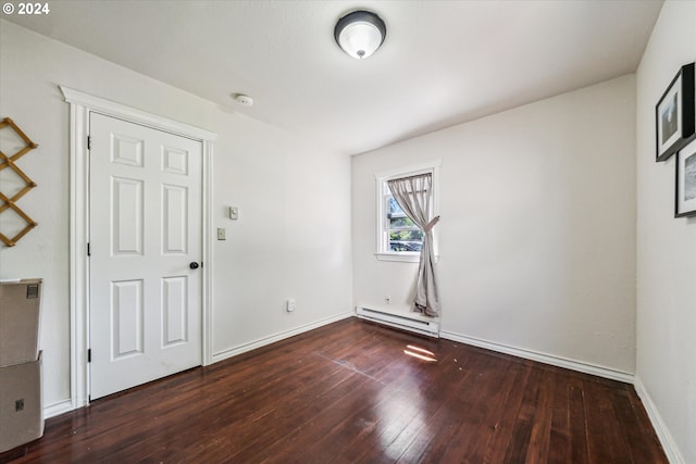 spare room featuring dark hardwood / wood-style flooring and a baseboard radiator