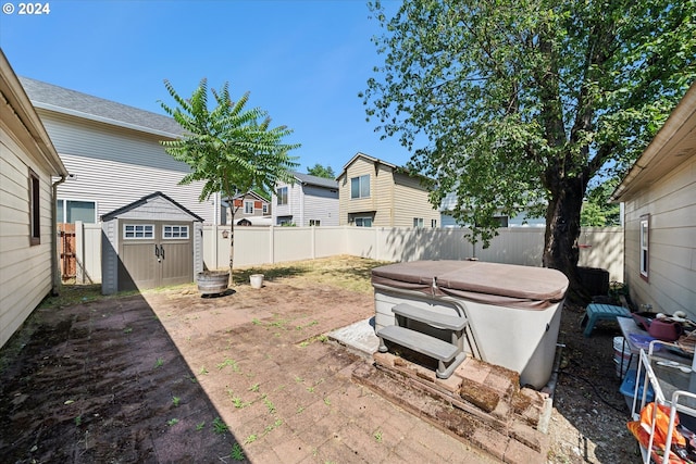 view of yard with a shed and a hot tub