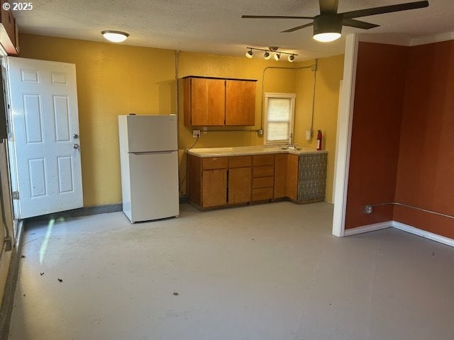 kitchen featuring ceiling fan, a textured ceiling, and white refrigerator