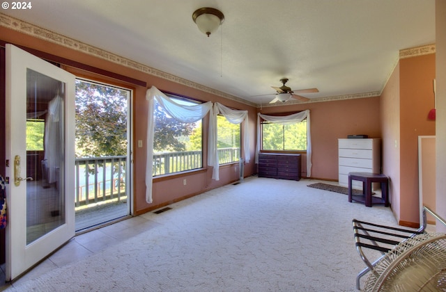 unfurnished sunroom featuring ceiling fan and plenty of natural light