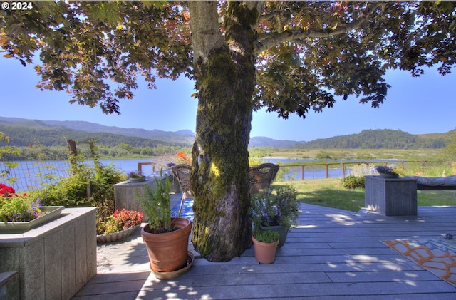 wooden deck featuring a water and mountain view