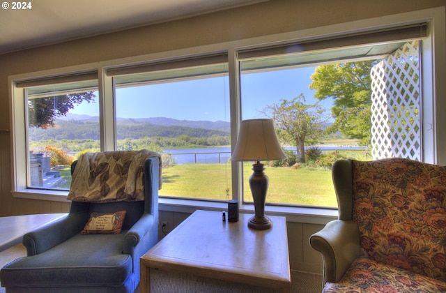 sitting room featuring a water and mountain view and a wealth of natural light