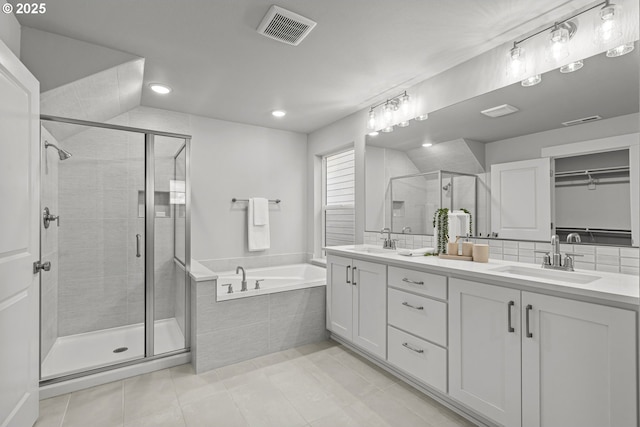 bathroom with independent shower and bath, vanity, tile patterned flooring, and decorative backsplash