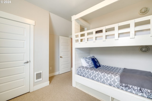 bedroom featuring heating unit and light colored carpet