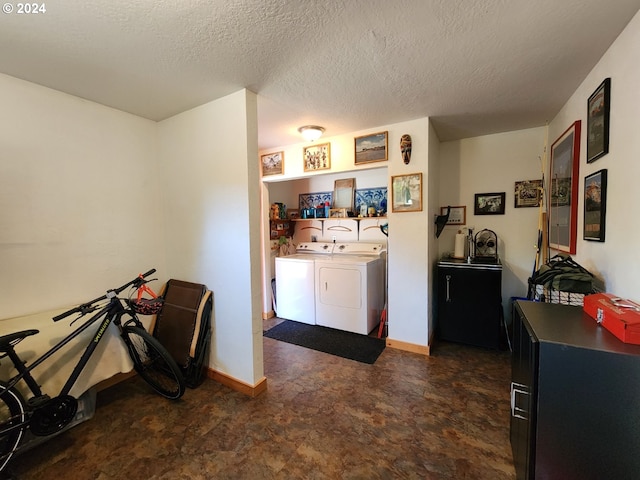 interior space with washing machine and dryer, a textured ceiling, and baseboards
