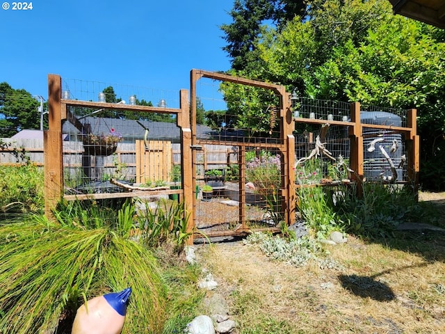 view of play area featuring a vegetable garden and fence