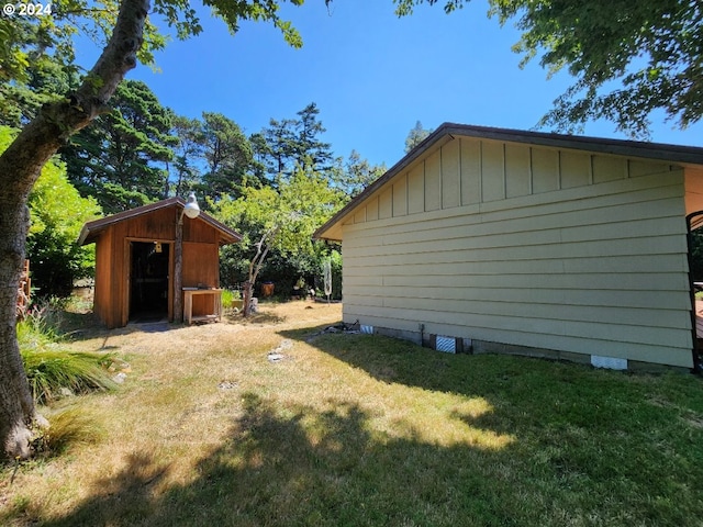 view of home's exterior with an outbuilding, a lawn, and a shed