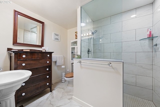 bathroom with a tile shower and toilet