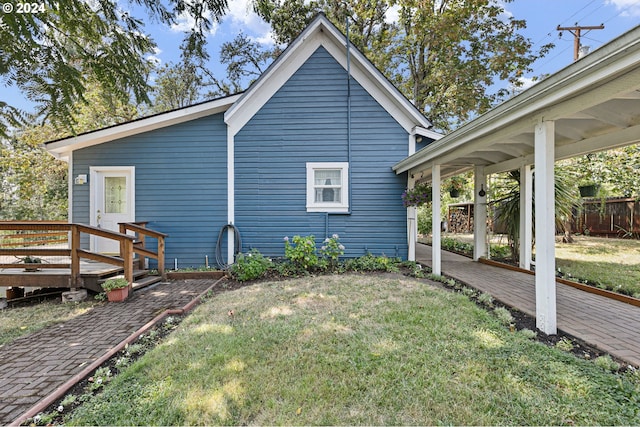 back of property featuring a yard and a wooden deck