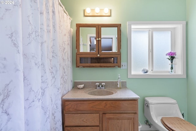 bathroom with vanity, toilet, and walk in shower