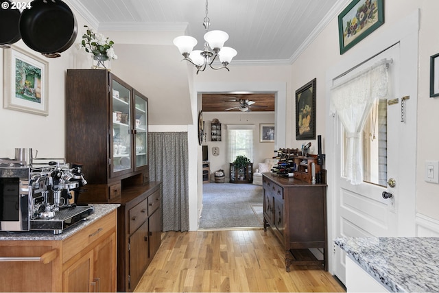 kitchen featuring light stone counters, hanging light fixtures, light hardwood / wood-style flooring, and ornamental molding