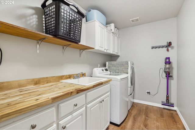 washroom featuring cabinets, separate washer and dryer, light hardwood / wood-style floors, and sink