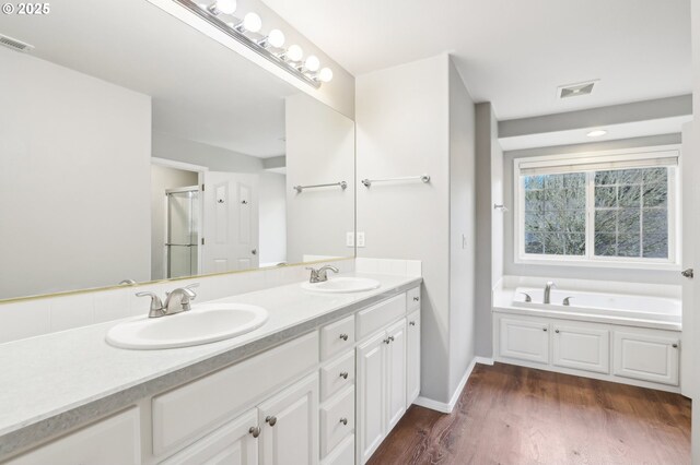 bathroom featuring hardwood / wood-style floors, vanity, and a bath