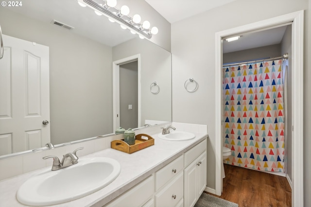 bathroom with vanity, hardwood / wood-style flooring, toilet, and curtained shower