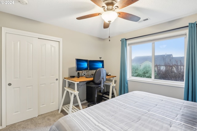 bedroom with ceiling fan, carpet floors, and a closet