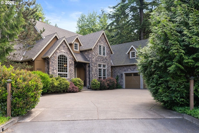 12320 NW Sargent Ln, Portland, OR 97231 - view of front of property featuring stone siding, driveway, and an attached garage