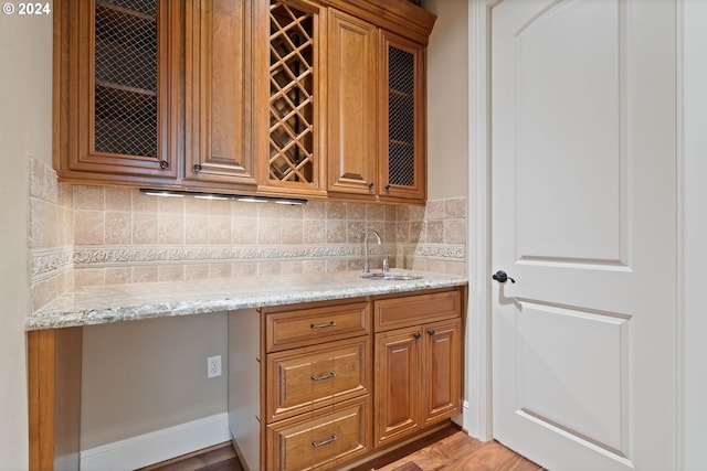 12320 NW Sargent Ln, Portland, OR 97231 - kitchen featuring a sink, backsplash, light stone countertops, and brown cabinetry