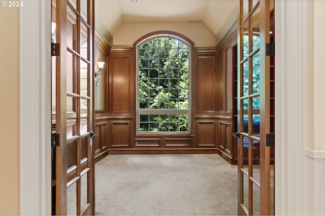 interior space featuring light colored carpet, french doors, and vaulted ceiling